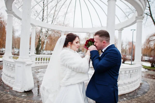 Smyslné svatební pár na pozadí bílého oblouku s sloupce za sloupec — Stock fotografie