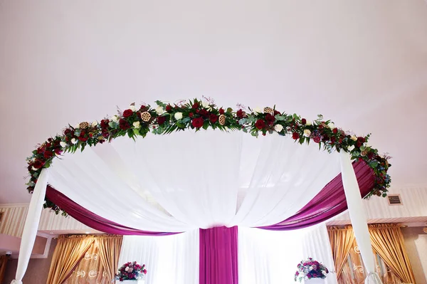 Arc de mariage avec des fleurs de table jeunes mariés . — Photo