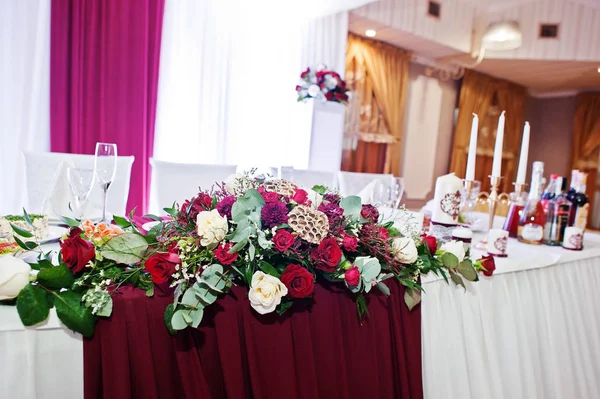 Flores de boda de rosas blancas y rojas en mesa de recién casados . — Foto de Stock