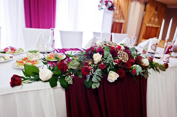 Bruiloft bloemen van witte en rode rozen op tafel voor pasgetrouwden. — Stockfoto