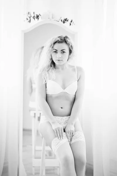 Lockigt blond flicka i underkläder bakgrund spegel inomhus vit ro — Stockfoto