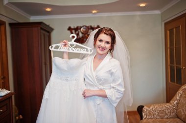 H holding beyaz ipek elbise elbise giymiş esmer gelin gülümseyen