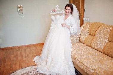 H holding beyaz ipek elbise elbise giymiş esmer gelin gülümseyen