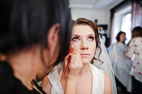 Stylist fa trucco sposa il giorno del matrimonio al salone beaty . — Foto Stock