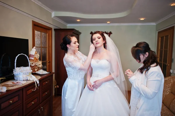 Brautjungfern helfen gekleideten Braut am Hochzeitstag am Morgen. — Stockfoto