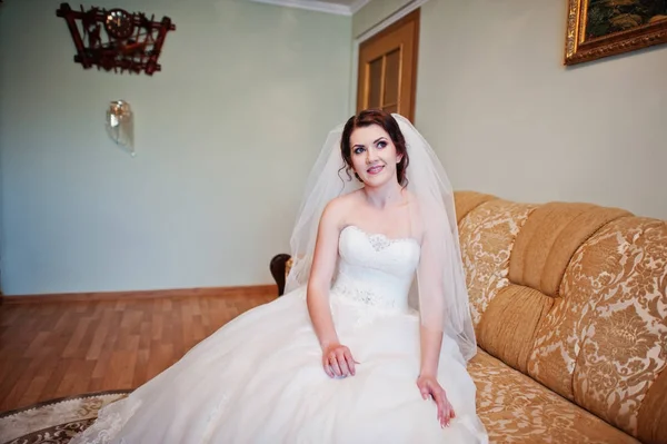 Nabídka brunetka nevěsta sedí na posteli ve svém pokoji v mornig svatební — Stock fotografie