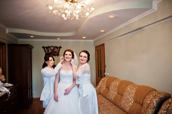 Dama de honra ajudando noiva vestida no dia do casamento na manhã . — Fotografia de Stock