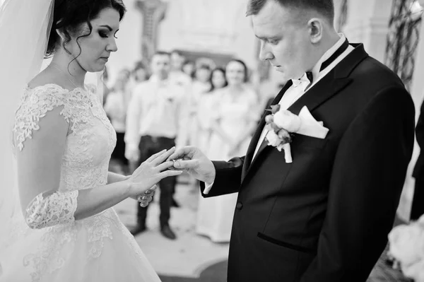 Γαμπρός βάζει ένα γαμήλιο δαχτυλίδι στο χέρι της νύφης στην αίθουσα του δημιουργία λογαριασμού — Φωτογραφία Αρχείου