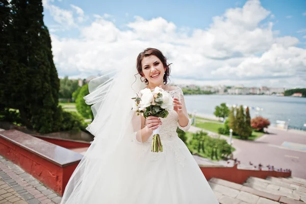 Joyeux mariée brune contre le ciel bleu avec des nuages étonnants ba — Photo