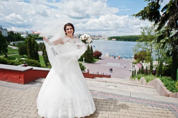 Cheerfull brunette bride against blue sky with amazing clouds ba — Stock Photo, Image