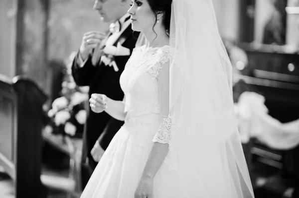 Bruidspaar tijdens huwelijk ceremonie binnen kerk. Zwart en whit — Stockfoto