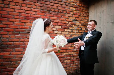 Güzel düğün çift arka plan tuğla duvar kal.