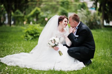 Yeşil çimenlerin üzerinde oturan ve birbirimizi Düğün çifti.