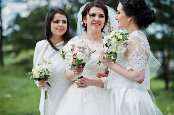 Hezká nevěsta s družičky na bílé šaty s kytice na — Stock fotografie