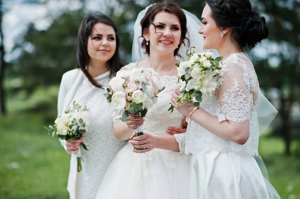 Bonita novia con damas de honor en vestidos blancos con ramos de flores —  Fotos de Stock