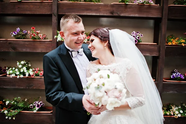 Beau mariage couple séjour fond mur avec des fleurs sur po — Photo