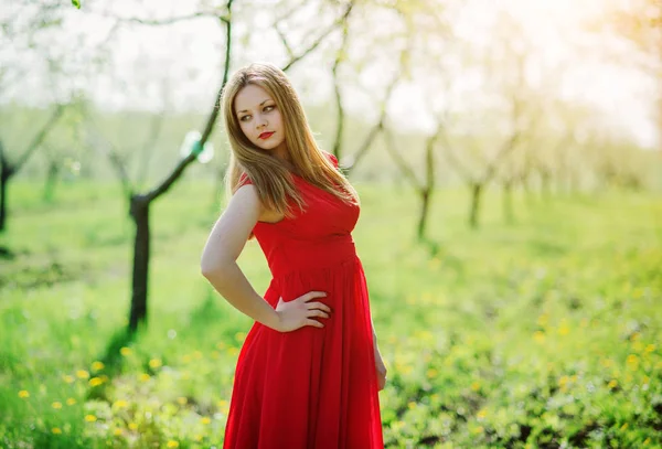 Porträt von hellhaarigen Mädchen auf rotem Kleid Hintergrund Frühling Garde — Stockfoto