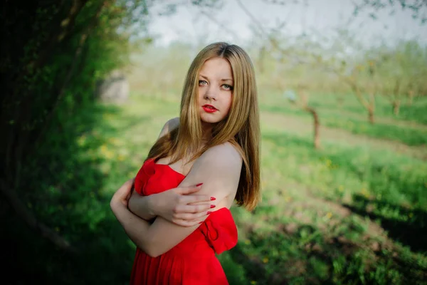 Porträt von hellhaarigen Mädchen auf rotem Kleid Hintergrund Frühling Garde — Stockfoto