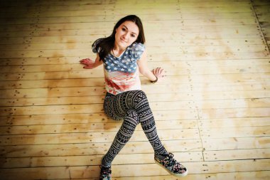 Footless oturma ba üzerinde rahat kıyafetler giyen sokak dansçı kız