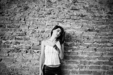 Genç şirin esmer kız arka plan tuğla duvar portresi.