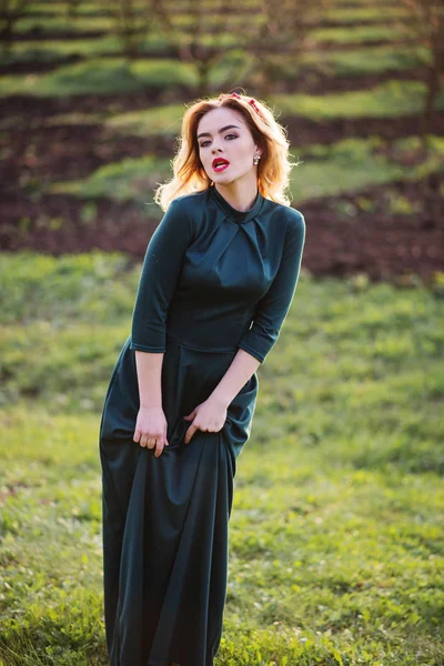 Yong elegance blonde girl at green dress on the garden in spring — Stock Photo, Image