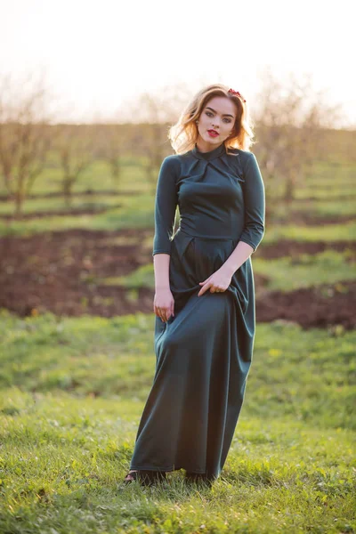 Yong κομψότητα ξανθιά κοπέλα στο πράσινο φόρεμα στον κήπο την άνοιξη — Φωτογραφία Αρχείου