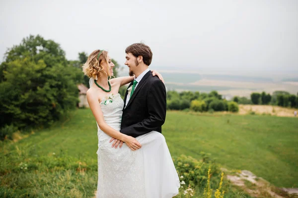 Abrazando pareja de boda en el amor en el tiempo nublado al aire libre . —  Fotos de Stock