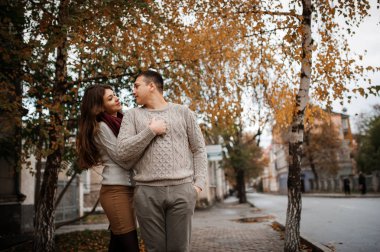 CI, aşık sarılma bağlı sıcak kazak giyen genç Çift