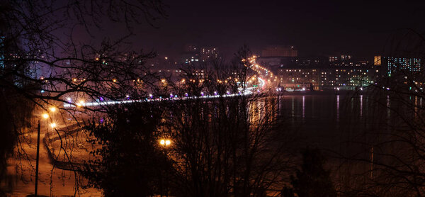 Panorama of night city lights and reflections on lake at Ternopil, Ukraine, Europe.