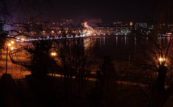 Panorama of night city lights and reflections on lake at Ternopil, Ukraine, Europe.