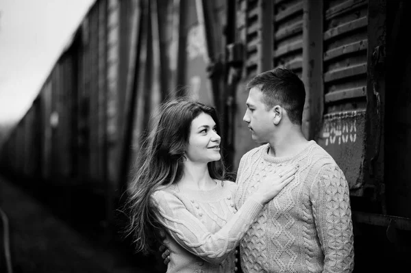 Jovem casal vestindo no amarrado quente suéteres abraçando no amor no ra — Fotografia de Stock