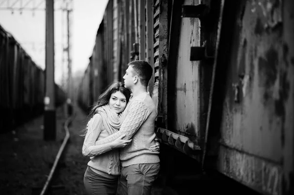 Jovem casal vestindo no amarrado quente suéteres abraçando no amor no ra — Fotografia de Stock