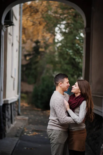 Young couple wearing on tied warm sweaters hugging in love under — Stock Photo, Image