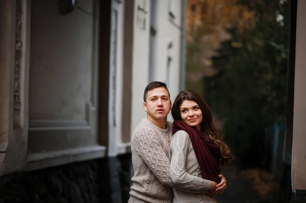 Joven pareja vistiendo en atado caliente suéteres abrazándose en amor bajo —  Fotos de Stock