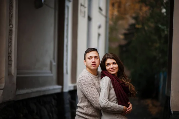 Young couple wearing on tied warm sweaters hugging in love under — Stock Photo, Image