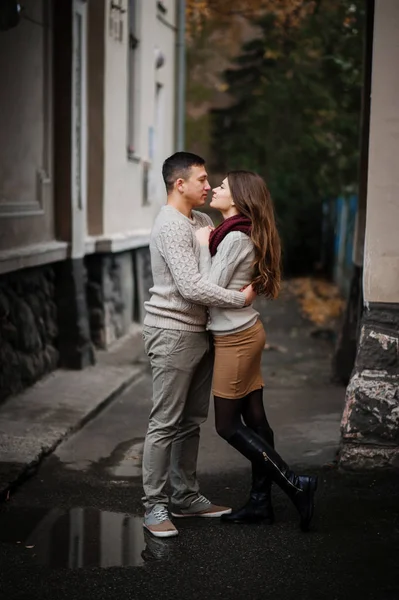 Young couple wearing on tied warm sweaters hugging in love under — Stock Photo, Image