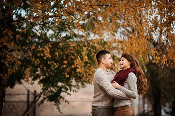 Pareja joven vestida con suéteres calientes atados abrazándose en el amor en ci —  Fotos de Stock