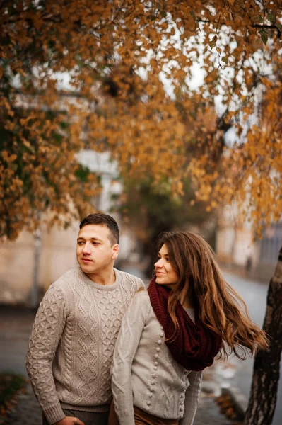 Jovem casal vestindo no amarrado quente suéteres abraçando no amor no ci — Fotografia de Stock