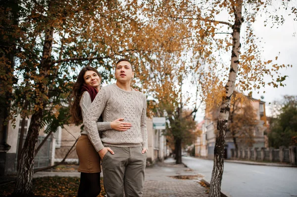 Ungt par bär på bundet varma tröjor kramas i kärlek vid KI — Stockfoto