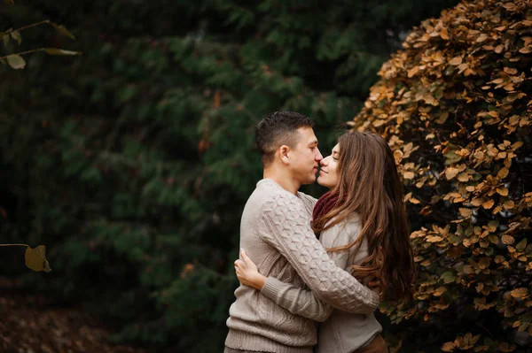 Pareja joven vestida con suéteres calientes atados abrazándose en el amor en ci —  Fotos de Stock