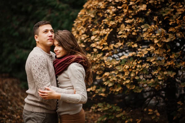 Young couple wearing on tied warm sweaters hugging in love at ci — Stock Photo, Image