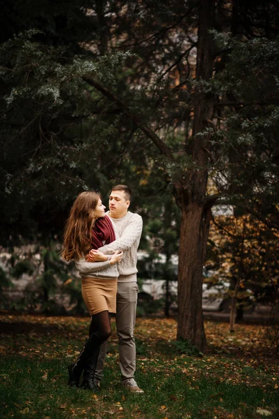 Молода пара, одягнена в прив'язані теплі светри, обіймає в коханні в чі — стокове фото