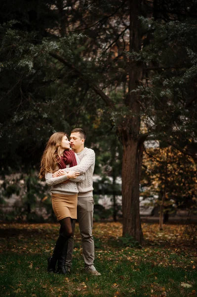 Pareja joven vestida con suéteres calientes atados abrazándose en el amor en ci —  Fotos de Stock