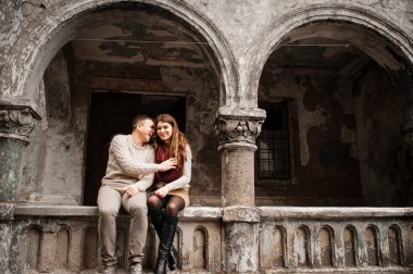 St üzerinde oturan aşık bağlı sıcak kazak giyen genç Çift