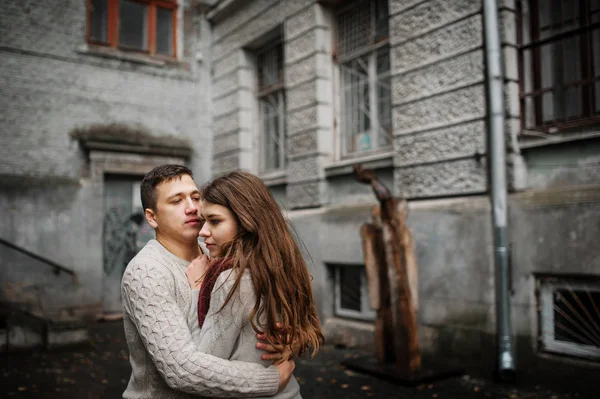 Jovem casal vestindo no amarrado quente suéteres abraçando no amor no ol — Fotografia de Stock