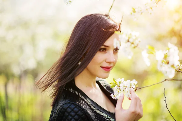 Gros plan portrait de jeune fille brune avec des fleurs de cerisier à — Photo