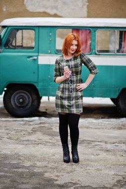 Genç kırmızı saçlı kız Bayan hareket eden hücre telefon ve kulaklık ile