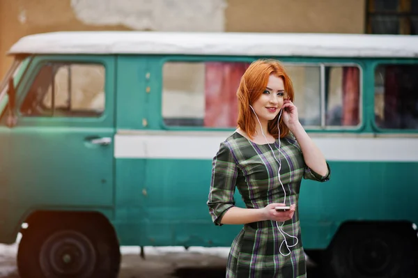 Jeune fille aux cheveux rouges dame avec téléphone portable et écouteurs — Photo