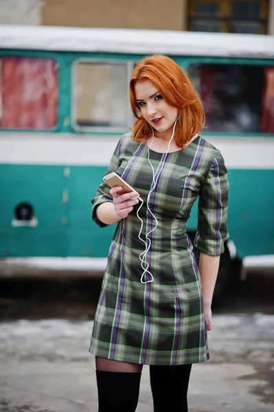 Joven chica pelirroja con teléfono celular y auriculares —  Fotos de Stock