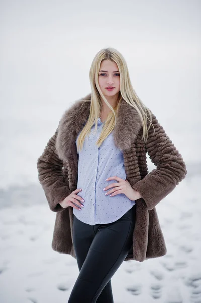 Portret van jonge elegantie blond meisje op de achtergrond van een bont jas — Stockfoto